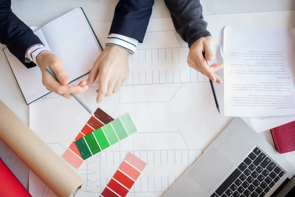Plans, nuancier et devis sur un bureau pour préparer les travaux d'un logement loué